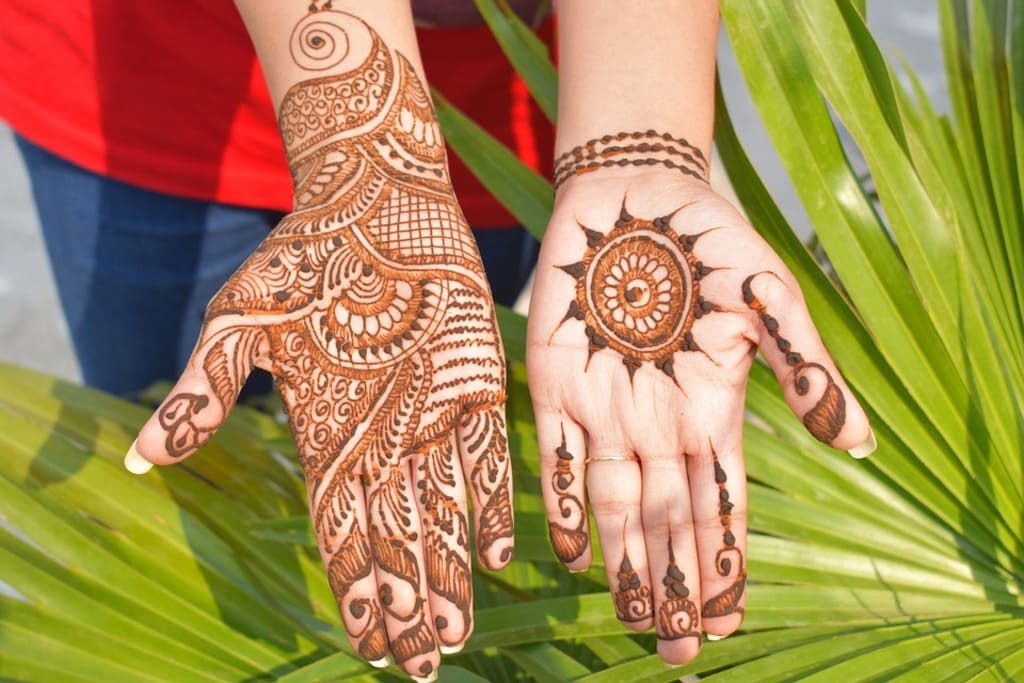 Top down video of a woman copying the mehndi henna tattoo from one hand to  the other in preparation of the hindu festival of teej, karwachauth, diwali  dussera or a marriage function,